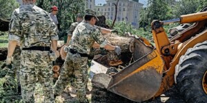 Милиционеры и военнослужащие внутренних войск МВД помогают расчищать дороги и дворы от поваленных ураганом деревьев